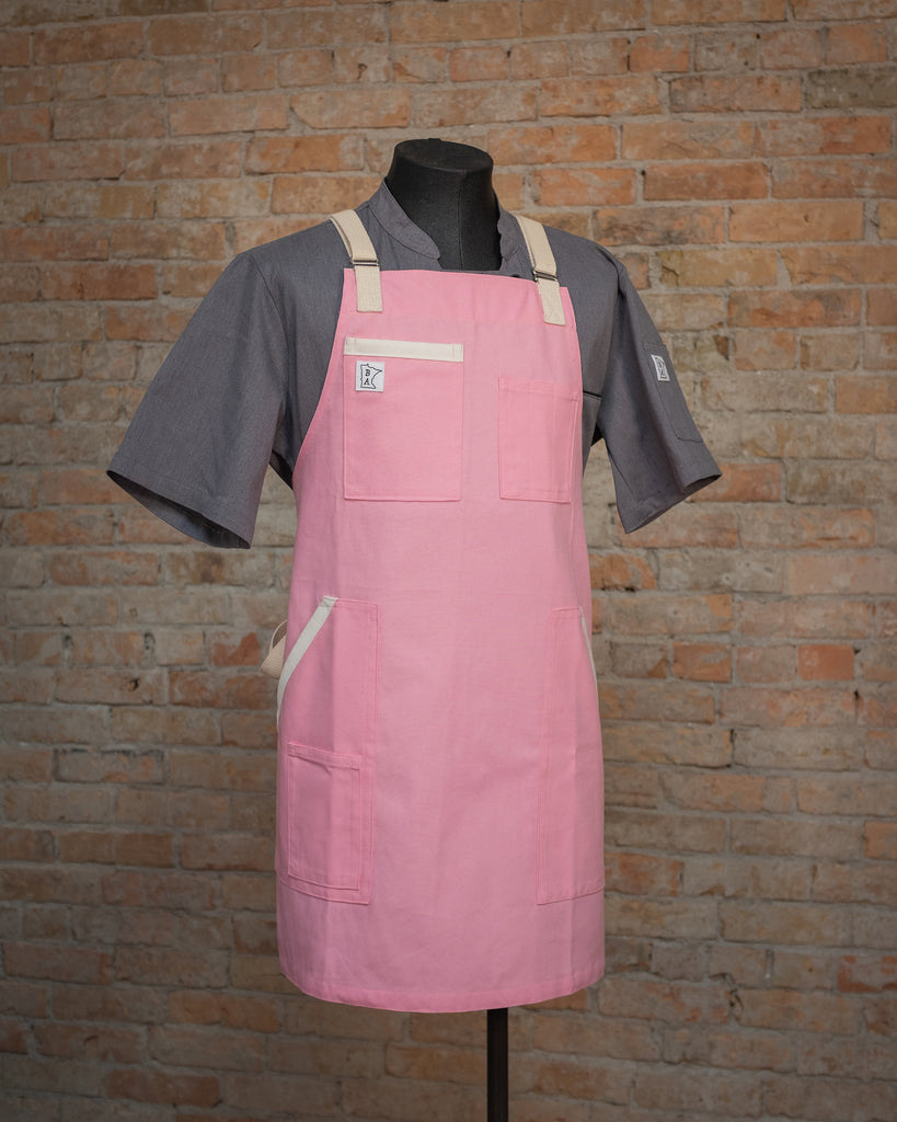 The cotton duck cloth apron design Penny Lane displayed on a mannequin over a gray chef coat. Both the chef coat and the apron were designed in Minnesota by Craftmade Aprons.