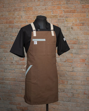 Duck cloth apron design Sea Mist displayed on a mannequin over a black chef coat. Both the chef coat and the apron were designed and produced by Craftmade Aprons.